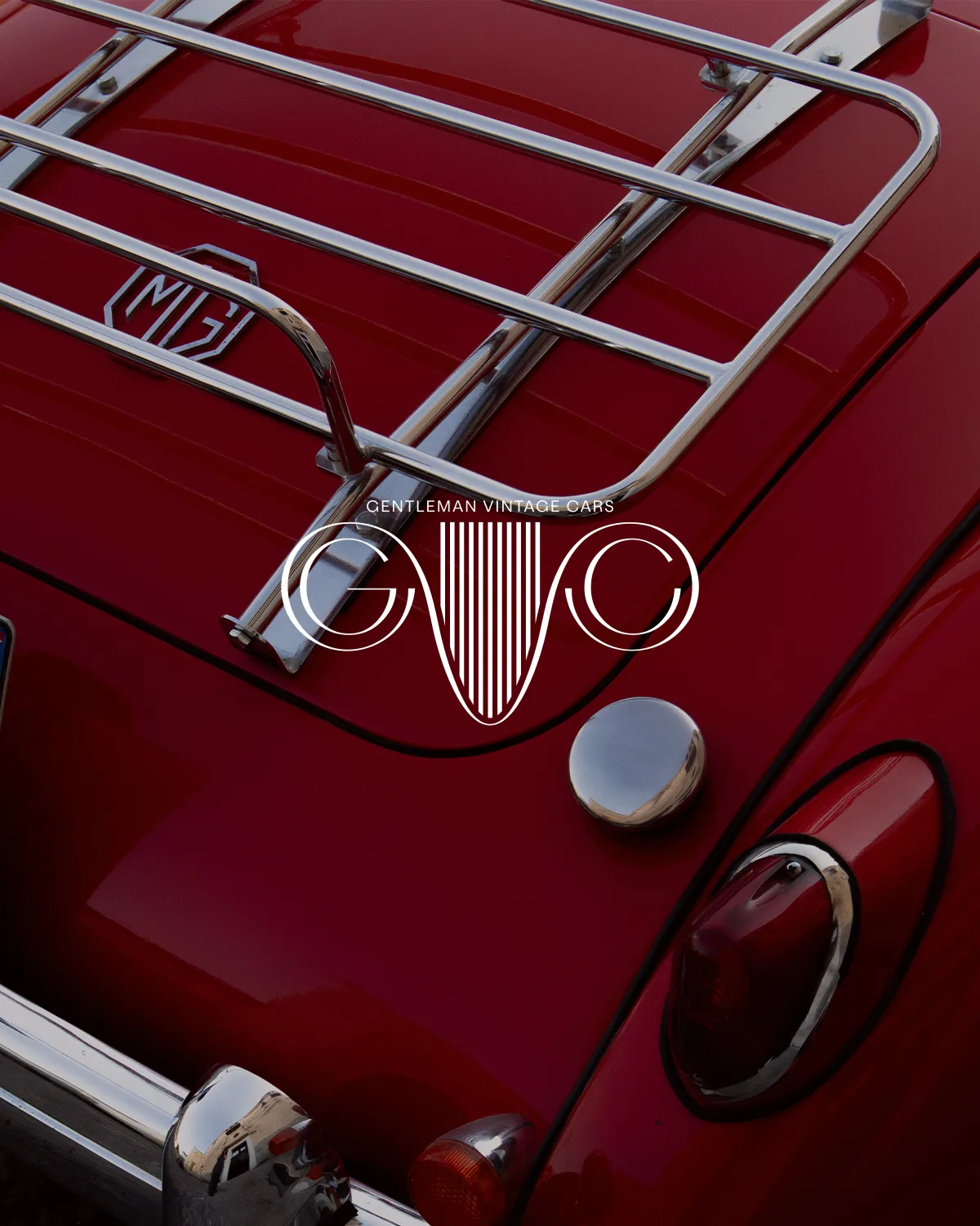 Gentleman Vintage Cars GVC monogram over the chrome luggage rack of a red MG