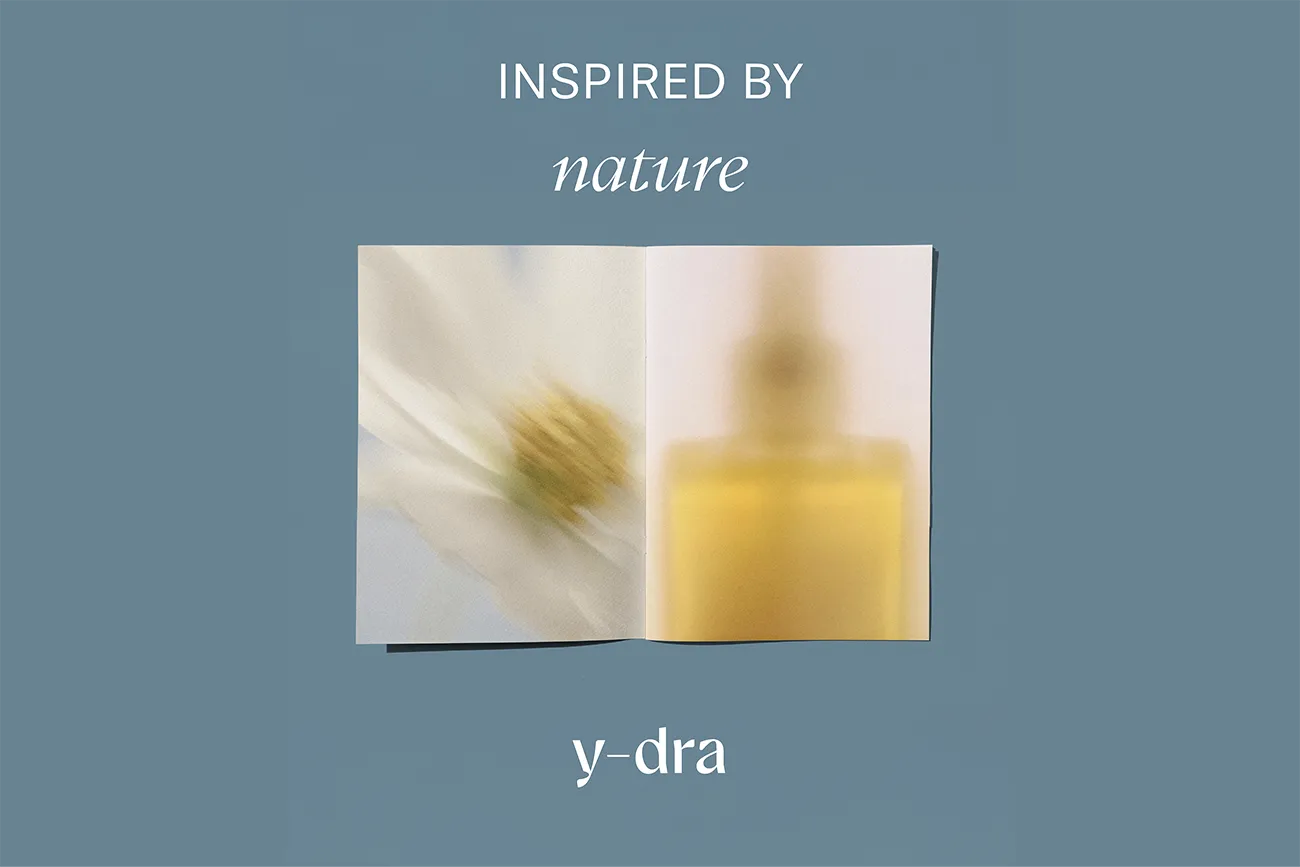 Open Y-dra booklet titled Inspired by nature, with blurred flower and oil bottle photos